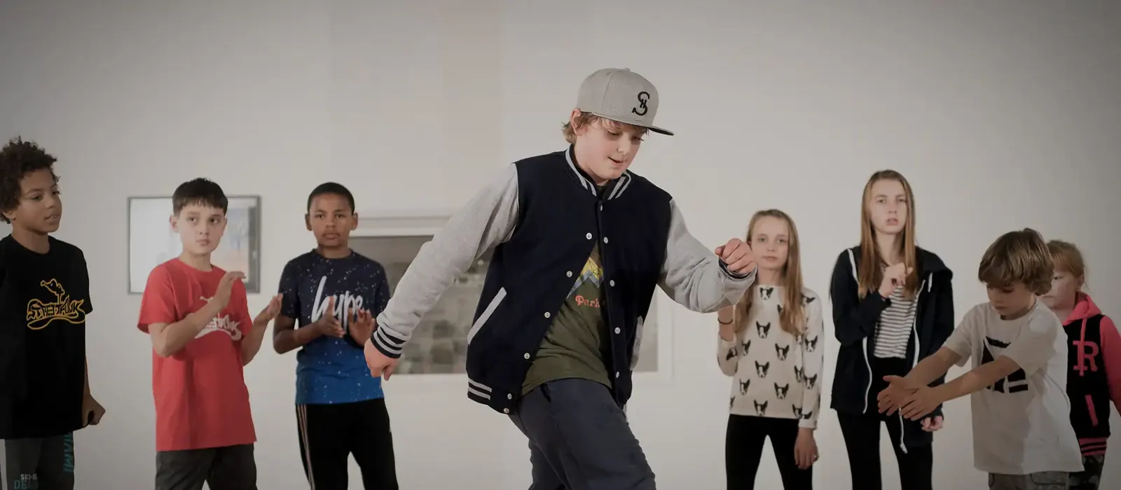 A young co-teacher demonstrating moves to a class