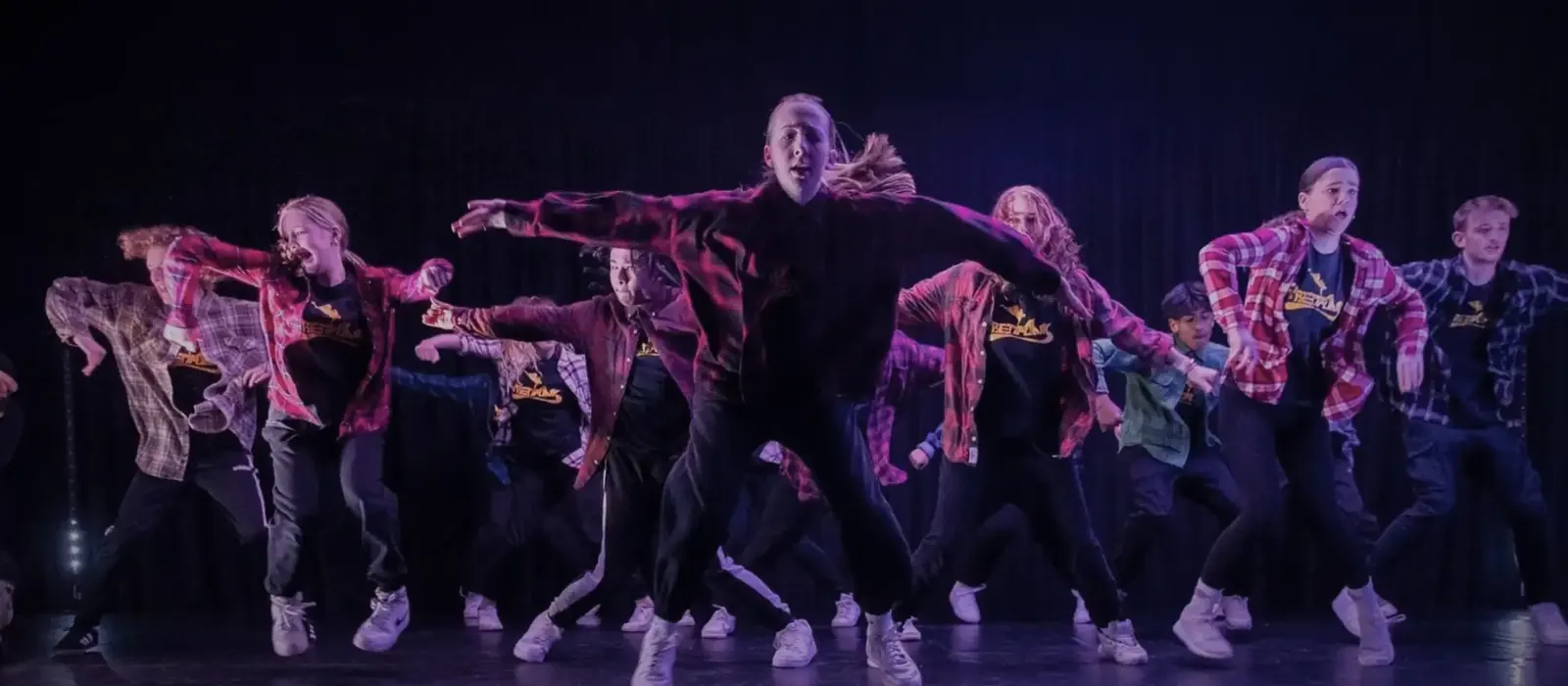 Streetfunk dancers performing on stage under purple lights